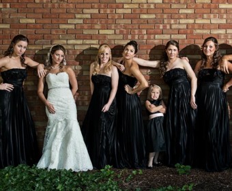 bridesmaids pose outside with brick wall